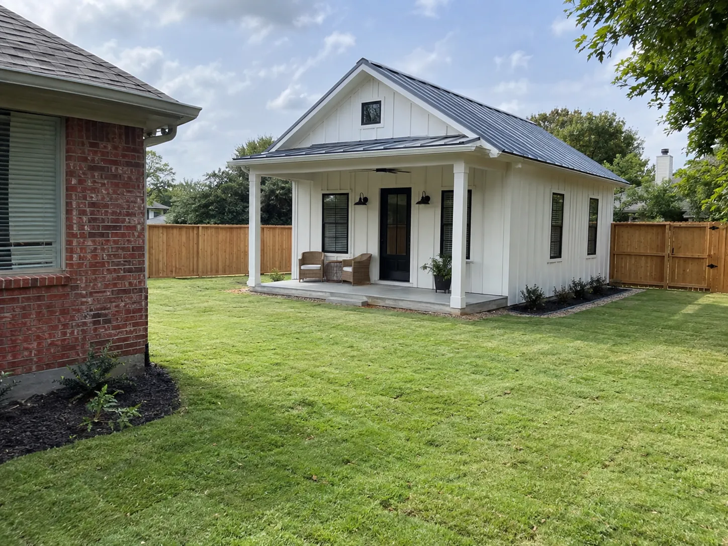 Detached backyard guest house behind a brick home
