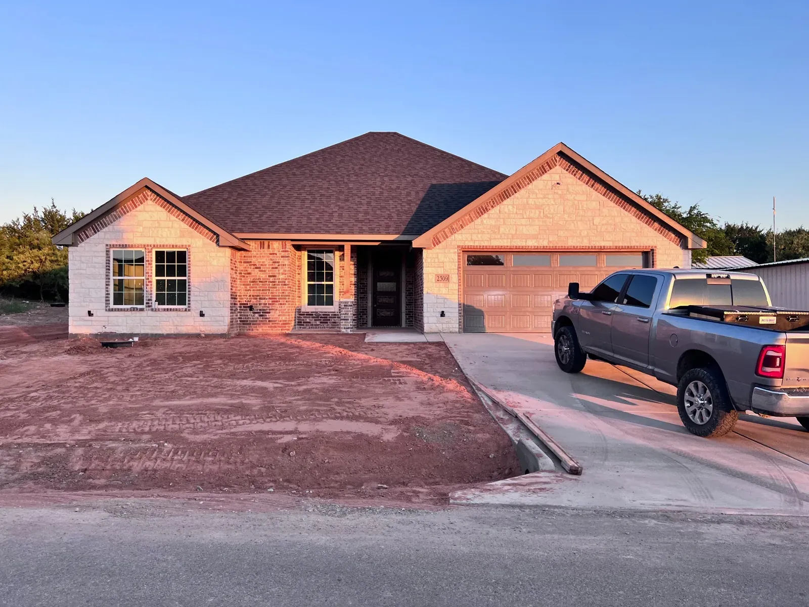 Newly completed brick home with a two-car garage and fresh driveway