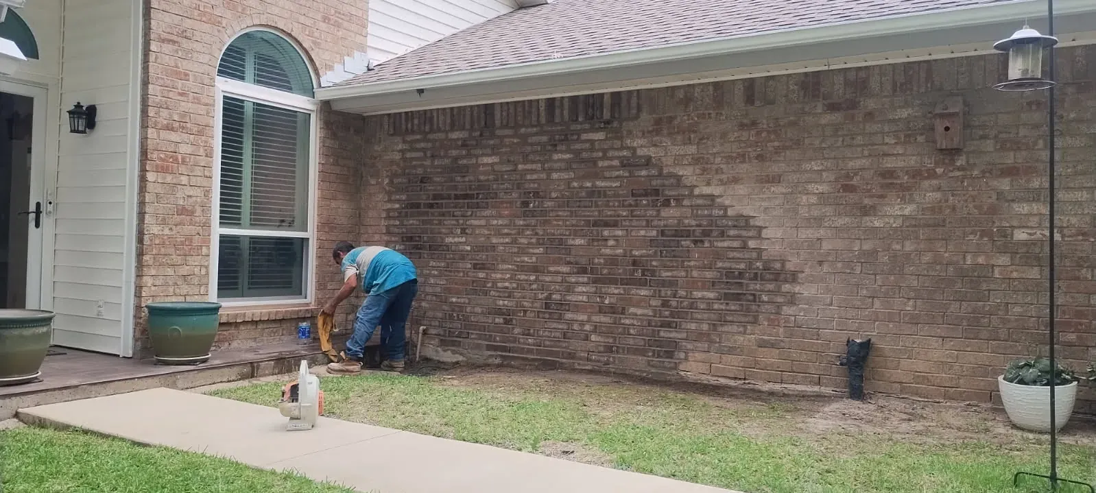 Mason repairing a damaged exterior brick wall