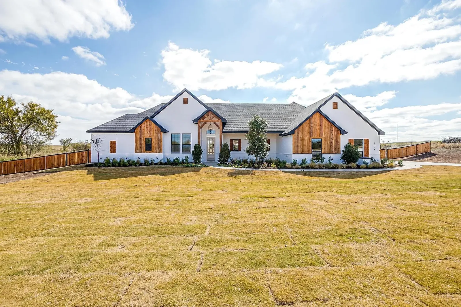 Completed farmhouse custom home with lawn