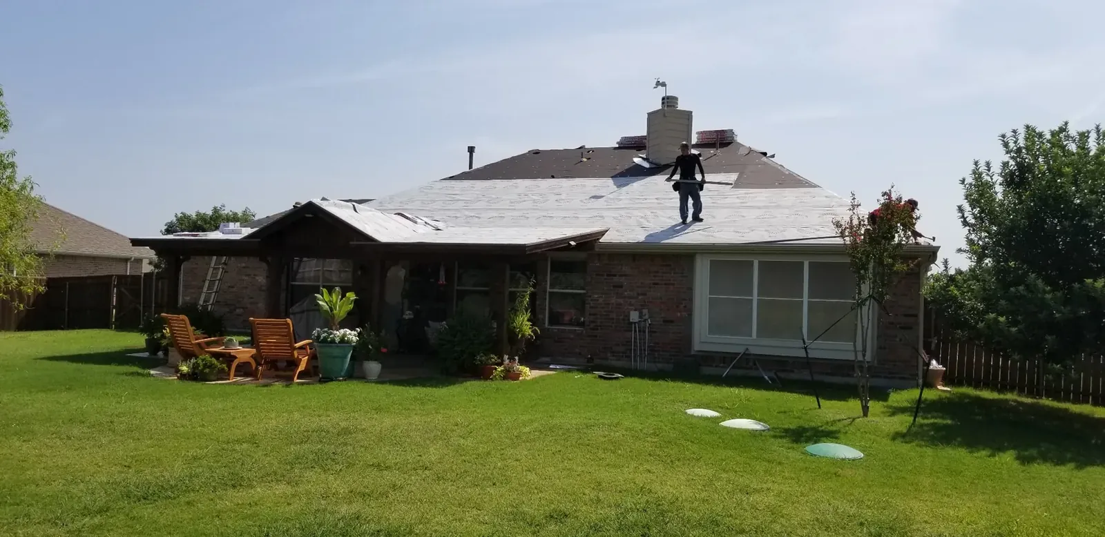 Roofing crew tearing off and replacing a residential roof